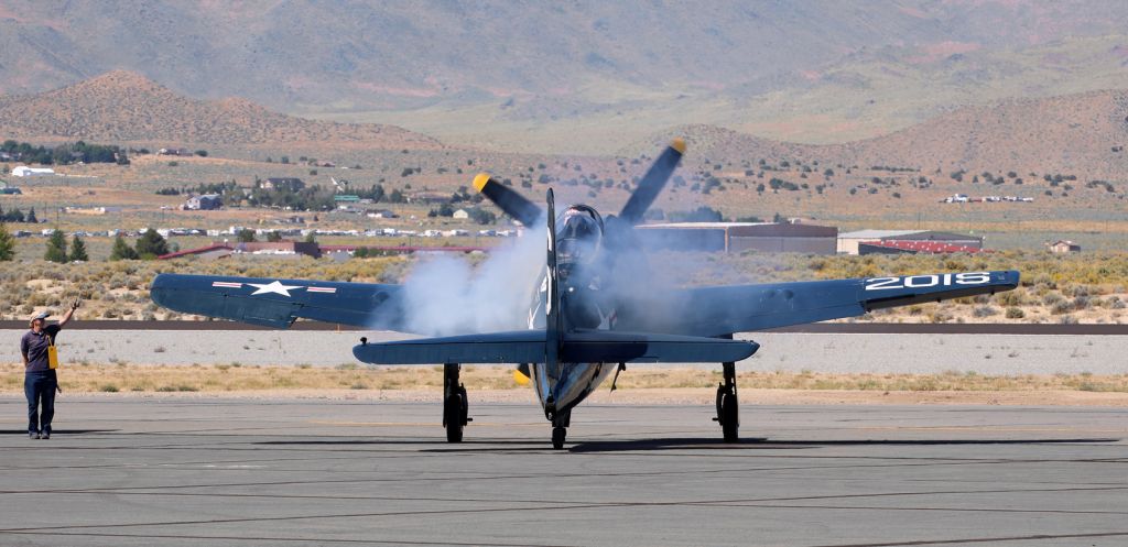 Grumman G-58 Bearcat (N7825C) - Shari Heitkotter, the lady ground crewperson of the Commemorative Air Force Southern California Wing's Grumman F8F-2 Bearcat (N7825C), gives the "thumbs up" for engine start to the pilot who is firing up the Bearcat's Pratt & Whitney R-2800-34W "Double Wasp" radial. 