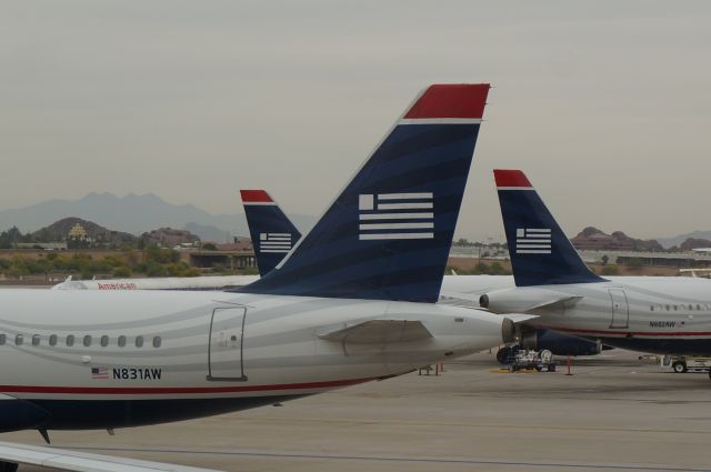 Airbus A320 (N831AW) - Tails, tails for days.  But big brother is always watching in the background.