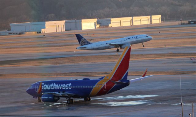 Boeing 737-700 (N724SW) - United A320 N404UA rotates from Rwy 14R as the Southwest B737 has completed de-icing.