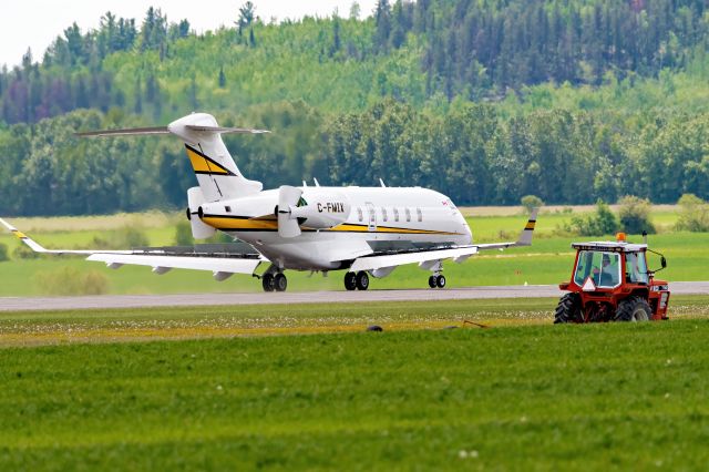 Canadair Challenger 350 (C-FMIX) - Taxing past a farm tractor after landing.