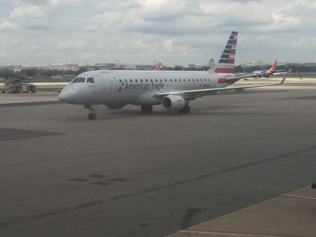 Embraer 175 (N122HQ) - E175 taxing with U.S. Capitol under renovation in background.