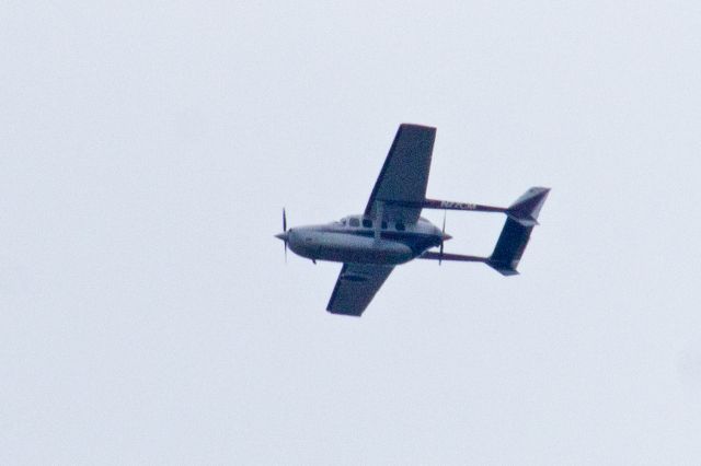 Cessna T337G Pressurized Skymaster (N77CM) - It was cloudy and chilly during the afternoon of 30-Mar-2018 at around 1511HrsEDT when this Cessna T337G appeared overhead apparently on its way to or from KCDW. Pushing the ISO to 800 and the EV to +1 stop at least got me enough to read the registration numbers. I hope I get another shot at getting a better picture of this aircraft type.br /br /This image is a tight crop of the original and enlarged 50%.