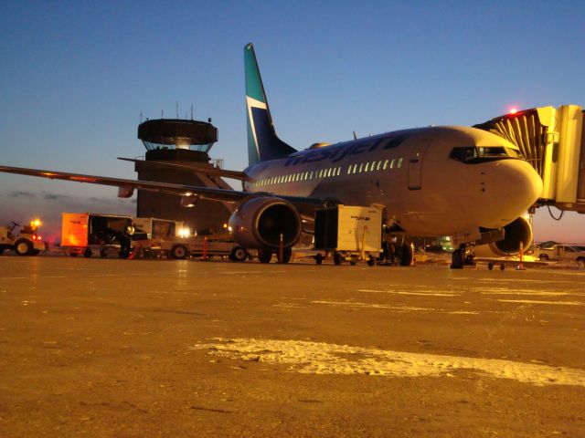 — — - WestJet at the gate at CYMM