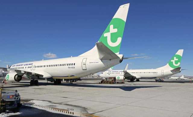 Boeing 737-800 (PH-HXA) - A pair of Transavia Airlines B738s on the ramp at Atlantic Aviation yesterday. Both of these 738s (PH-HXA and PH-HXC) are dressed in the hybid livery garb of Transavia / Sun Country because the two airlines regularly lease aircraft from each other's fleets. At this time of year, SCX is busier than Transavia so SCX leases from the Dutch airline. Later, when Sun Country's business decreases and Transavia becomes busier, TRA leases from SCX. The two aircraft seen in this pic are two of several that are routinely swapped between the two carriers.br /Both aircraft landed here yesterday morning from Cherry Point, North Carolina (KNKT), with full passenger loads of US Marines. Both B738s then flew back to KNKT and returned here again late last night with more Marines. 