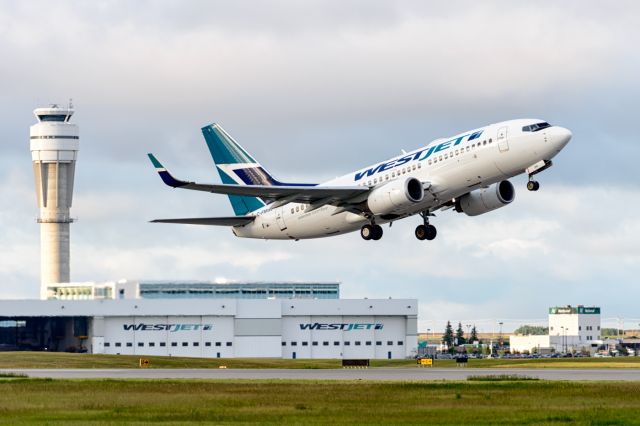 Boeing 737-700 (C-FMWJ) - WestJet taking off 17R in CYYC Calgary, Alberta, Canada near sunset