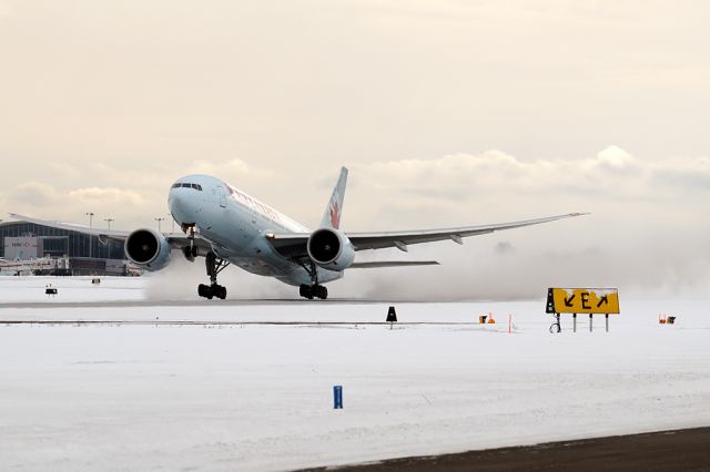 BOEING 777-200LR (C-FIUA) - blowing snow departing for Hong Kong.