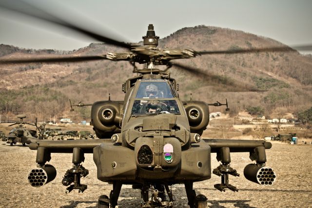 — — - A AH-64D executing gunnery operations prepares to take off from an improved landing site in Korea.