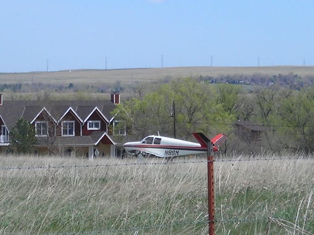 Beechcraft 35 Bonanza (N8SM) - damaged plane in field ... you can see that the left wing is missing.