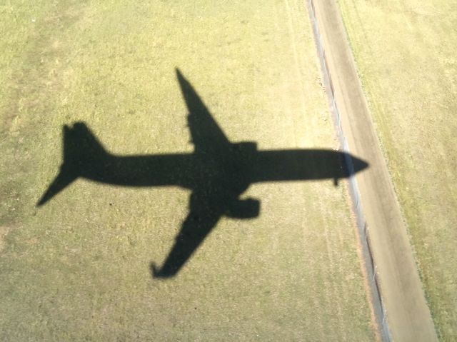 Boeing 737-800 (VH-VZB) - Landing into YMML on Runway 16 from YPAD. Took this photo almost by accident as noticed that the sun was right behind the aircraft which showed a perfect shadow on to the ground.