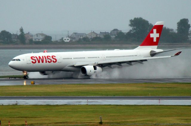 Airbus A330-300 (HB-JHM) - Swiss 54 from Zurich kicking up a spray landing on 33L