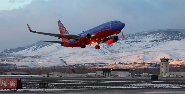 Boeing 737-700 (N774SW) - Just as the morning sun begins to light up the snow covered hills west of Reno, Southwest's N774SW is captured climbing away from runway 34L at the start of a 7 AM flight to Phoenix.