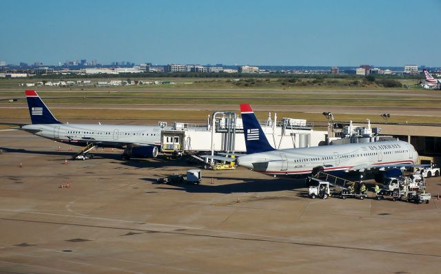Airbus A321 (N557UW) - US Airways A321-231 N557UW (nearest) next to sister N558UW at the E terminal's satellite concourse at DFW on Oct 30, 2014.