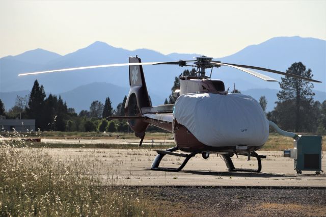 Eurocopter EC-130 (N413RX) - KRDD - REACH EC30 at the new Redding base - working out of an existing older building just south of the PHi Air Medical Base adjacent to the Redding Dragstrip gate/entrance. This is a new Helicopter base for Reach here at Redding and they are using 5th wheel trailers for crew quarters. A fuel truck is onsite and as you can see in the photo - portable air conditioning units - in which they will need daily soon! I noticed about 4 weeks ago equipment at this location but did not drive around the back side of RDD to see what this was - a new REACH base. May 2020