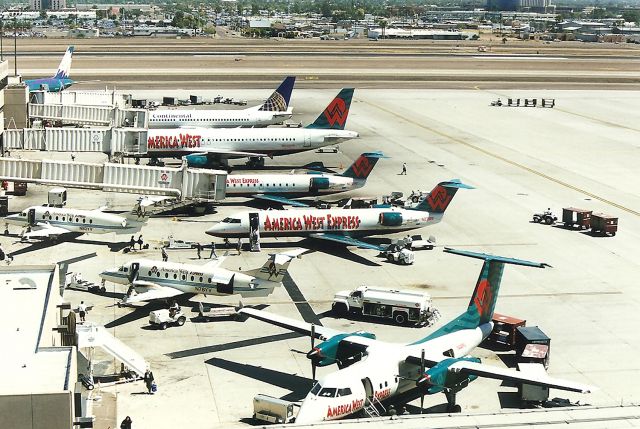 Beechcraft 1900 (N78YV) - KPHX - Busy ramp at Phoenix - I cant imagine what it is like to work in the summer when temperatures reach 115 degrees. UGH. Probably have to drink 10 gallons of water each shift. April 1998.