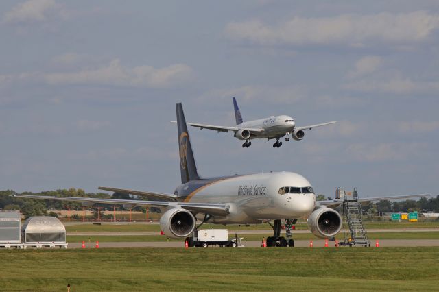 Boeing 777-200 (N223UA) - A double-shot of Boeings for you. Here, UA2533 Heavy was caught approaching a UPS B757-200 freighter, N416UP, on the UPS ramp during final approach for RWY 24R on 26 Sep 2020.