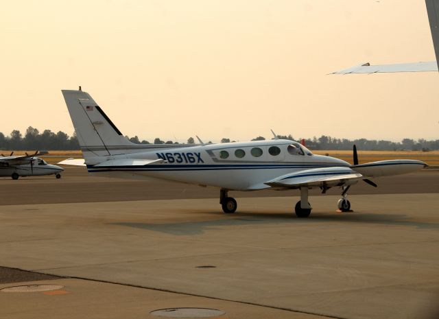 Cessna 340 (N6316X) - KRDD - 1978 Cessna 340A C/N 340A0487 at Redding parked next to a Government Metro # 625. Smoky skies this day due to the many wildfires burning in CA. 8-19-2017