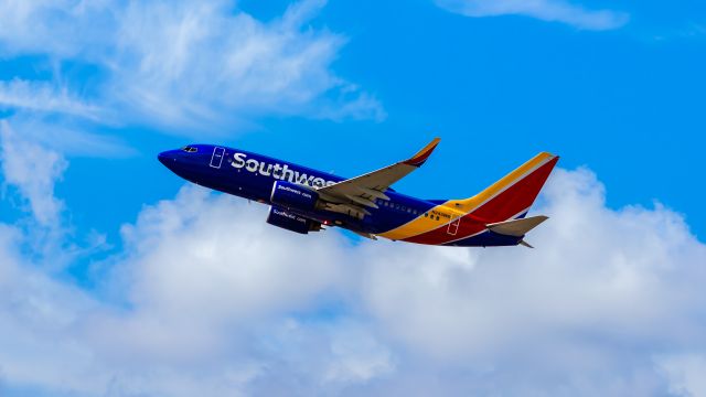 Boeing 737-700 (N243WN) - Southwest Airlines 737-700 taking off from PHX on 8/20/22. Taken with a Canon 850D and Rokinon 135mm f/2 manual focus lens.