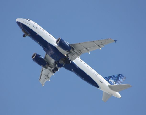 Airbus A320 (N594JB) - Jetblue A320 deploying wheels over the coast, as seen in the wing root reflection, from Luis Munoz Mari­n Intl in Puerto Rico, momentarily landing on 31R at a snowy JFK