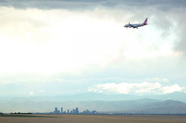 Embraer 170/175 — - Approach to 16R at KDEN under dark skies with Denver in the background.