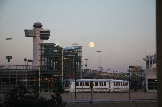 — — - 10/14/16 moonrise at JFK at sunset, as an Airtrain moves between T1 and T2-3.