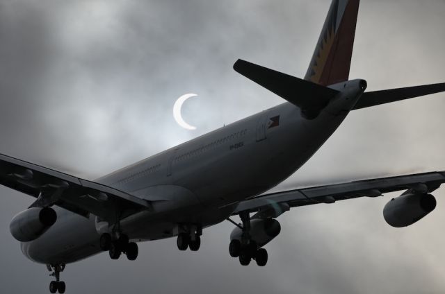 RP-C3434 — - A Phillipine Airlines Airbus A340 widebody jet passes in front of a partially eclipsed sun during its final approach to the Los Angeles International Airport, LAX, Westchester, Los Angeles, California