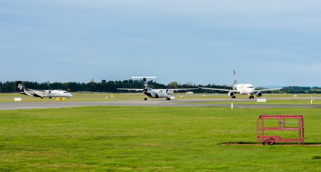 — — - Id just photographed the Air New Zealand Dash-8 / Q300 (in the middle) during its landing, got down off my ladder, changed lens, then realised they were all having a chit-chat with no one moving before the A320 eventually started taxying off gate 26 for F1. I then realised what was going on. It was quite entertaining wondering who was going to move first at first glance!