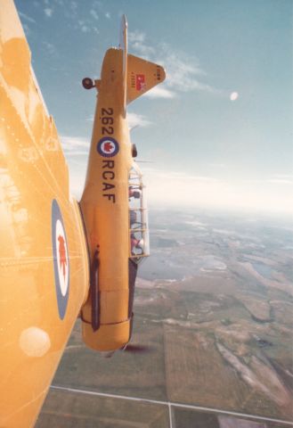 North American T-6 Texan (C-FSWW) - Promo shot from a wingtip camera mount during shooting of the CTV documentary 'The Flight of the Conroys.' Four members of the Conroy Family of Calgary, Alberta flew identical aircraft.