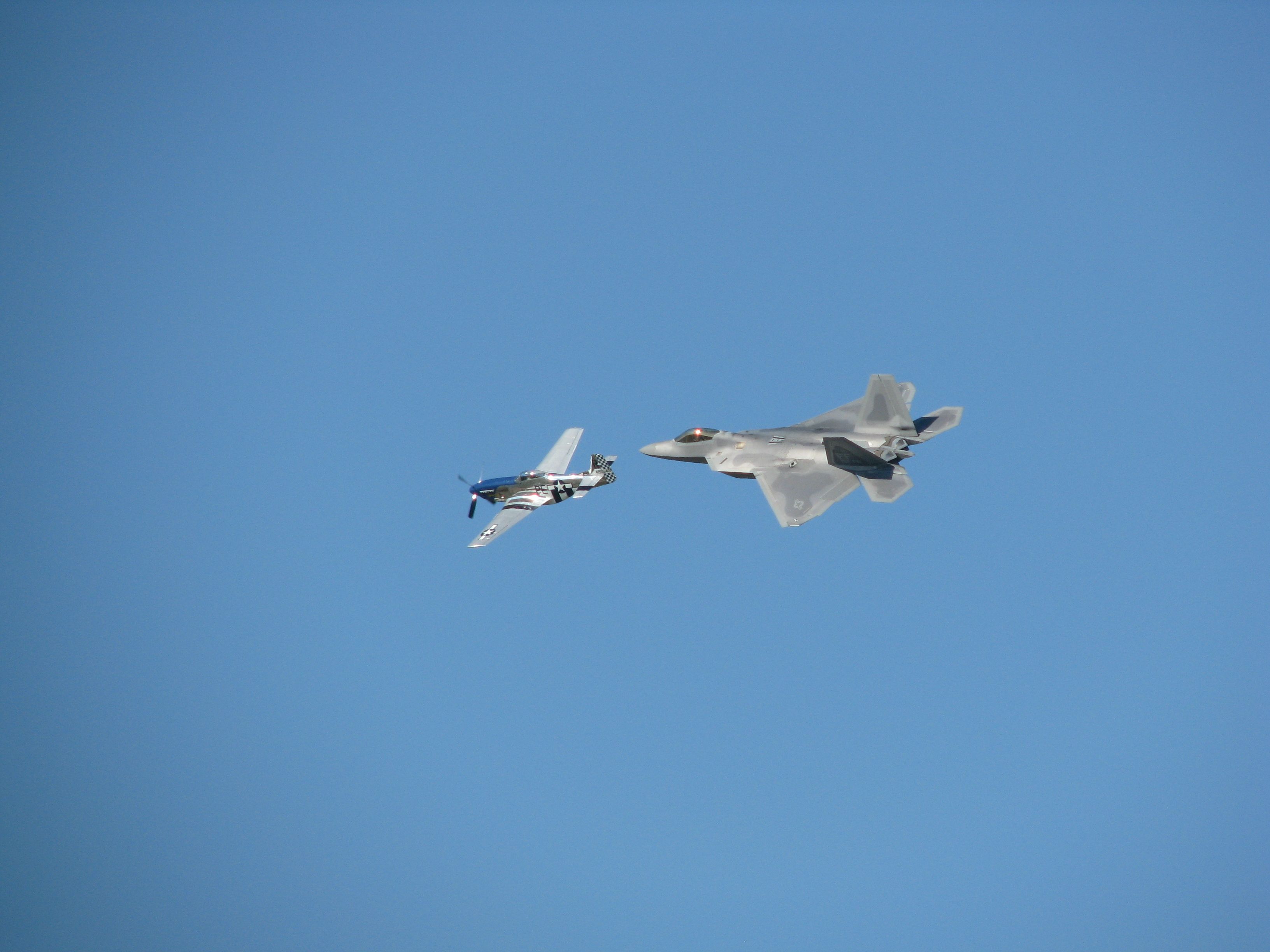 — — - P-51 Mustang and F-22 Raptor fly formation at Oshkosh 2008.