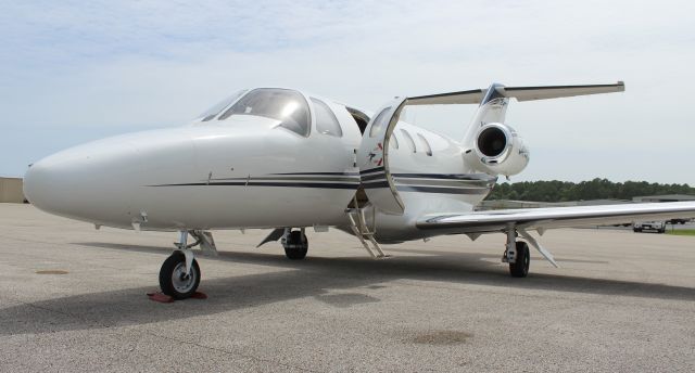 Cessna Citation CJ2+ (N573CM) - A Cessna C525 CitationJet under bright sunshine in a slightly tilted photo on the Gulf Air Center ramp at Jack Edwards National Airport, Gulf Shores, AL - June 19, 2018.