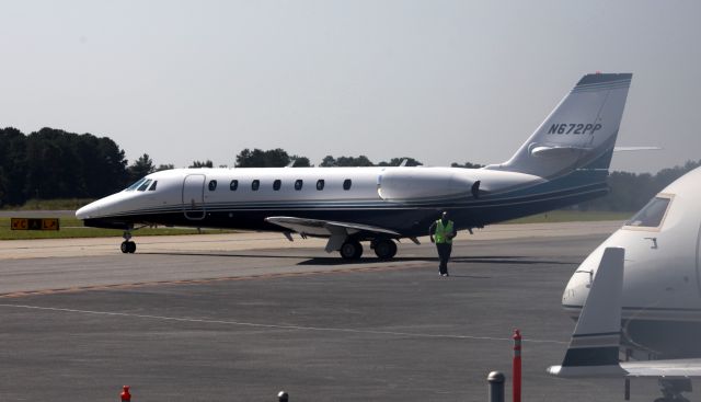 Bombardier Challenger 300 (N672PP) - Directed away from the terminal, the ground crew clears away