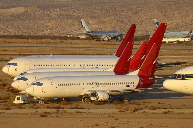 BOEING 737-400 (VH-TJL) - QANTAS Boeing 737-476 VH-TJL and a flock of former QANTAS 737s and 767s. VH-TJL first flew on October 30, 1991. Its construction number is 24437. It was delivered to Australian Airlines on November 12, 1991. It was merged into the QANTAS fleet on Halloween 1993. It was leased to Air Nauru on April 23, 2003 and returned to QANTAS on June 26, 2003. It was withdrawn from use and stored May 15, 2013. 