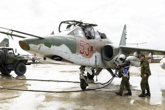 — — - A Russian pilot (L) walks near a Sukhoi Su-25 fighter jet shortly before the take-off, part of the withdrawal of Russian troops from Syria, at Hmeymim airbase, Syria, March 15, 2016. (Photo by Vadim Grishankin/Reuters/Russian Ministry of Defence)