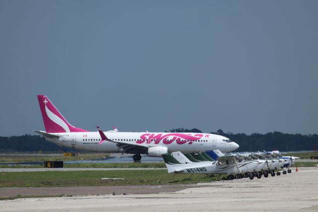 Boeing 737-800 (C-FYPB) - 4/16/23 taxiing in past a row of Cessnas