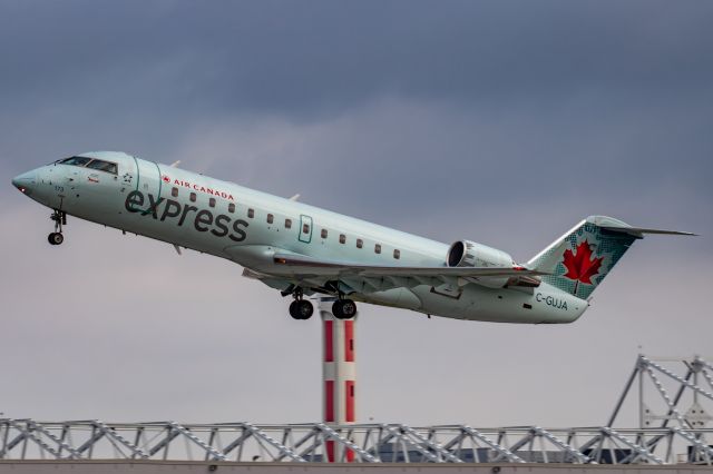 Canadair Regional Jet CRJ-200 (C-GUJA) - Jazz Aviation CRJ-200 leaving Montreal on a dreary July morning. 