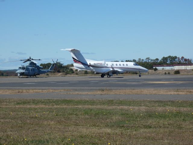 Embraer Phenom 300 (N459QS) - Taxiing for departure is this 2023 Embraer Phenom 300 in the Autumn of 2024. A US Marine Bell "Venom" Super Huey is also in the scene.