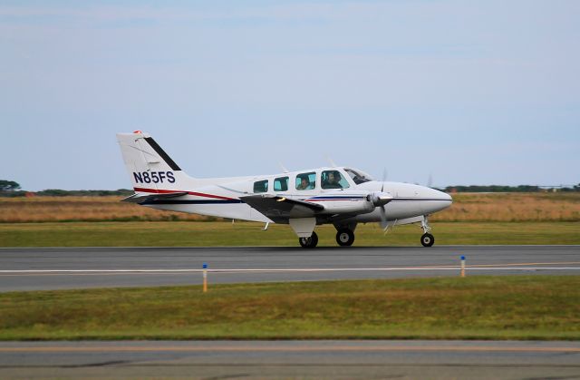 Beechcraft Baron (58) (N85FS) - Rolling out after landing on runway 24 at ACK. Not sure if the rear passenger is picking his nose or itching his face. You decide.