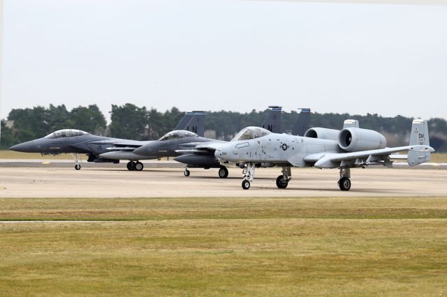 — — - On deployment to the UK in 2015, an A-10 taxiing behind a pair of Eagles as they get their last checks.