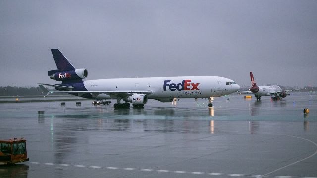 McDonnell Douglas DC-10 (N624FE) - A few minutes later...Virgin is still waiting for the gate to clear as FedEx heads down taxiway Delta and turns right heading south on taxiway Romeo at LAX during a heavy Pacific rainstorm.