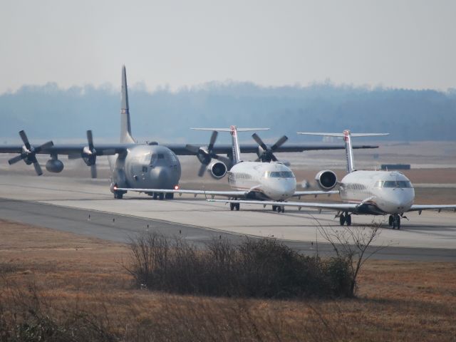 — — - Two US Airways Express CRJs followed by a NC Air National Guard C-130, taxiing to runway 18C (Charlotte, NC) - 2/10/09