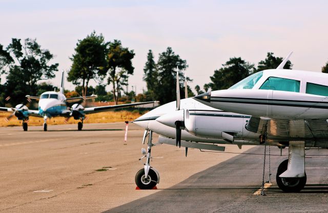 Cessna 310 (N310DH) - Cessna 310 parked on the ramp with a transient King Air 90 taxing out for departure. This 310 departed just a short time ago.