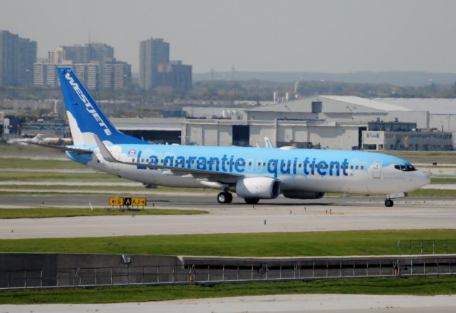 Boeing 737-700 (C-GWSZ) - Awaiting clearance to cross taxi way approaching Terminal 1 at Pearson International.