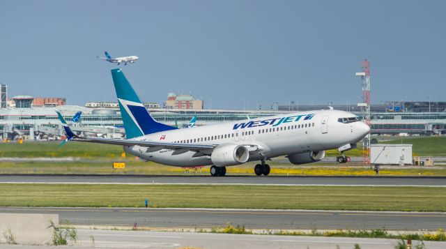 Boeing 737-800 (C-FKRF) - This west jet 738 gets airborne from runway 23 at YYZ as an Air Transat A330 is on short finals for the south parallel