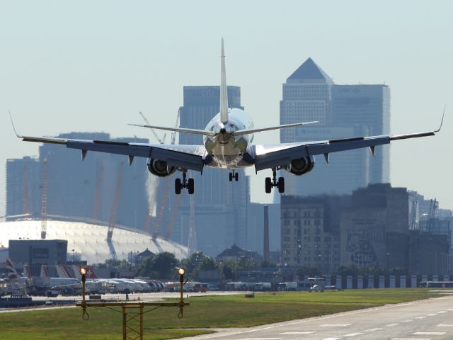 — — - A British Airways Embraer E170 approaches London City Airport with a slight cross wind component. Note the raised spoilers that allows the Embraer to approach London City at a 5 degree glide slope, versus the standard 3 degree approach used at other Airports.