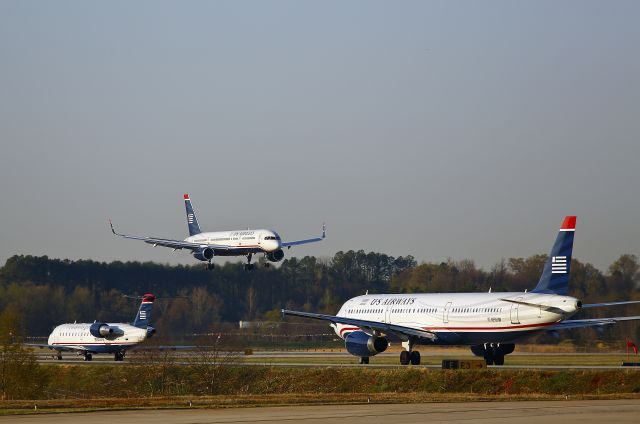 Boeing 757-200 (N200UU) - A US Airways Boeing 757 prepares to land as Airbus N535UW is taxiing for takeoff at runway 36C, Charlotte, North Carolina USA