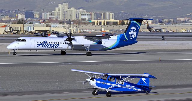 CHAMPION Sky-Trac (N16RG) - N16RG, a Citabria, taxies south on Charlie as a QX Dash 8 has the mains down and rolling and the nose gear tires just about to touch down on 16L.