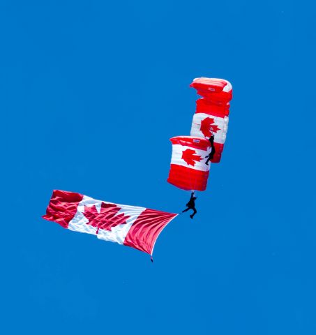 — — - The Canadian Forces Parachute Team displaying the Canadian Flag at the opening ceremonies at this years Quinte Airshow. 