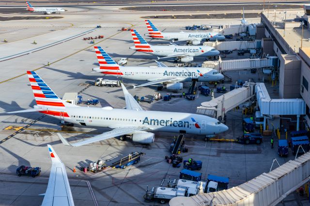 Boeing 737-800 (N993NN) - American Airlines planes parked at Terminal 4 at PHX on 11/28/22, with the AstroJet retro livery 737-800 parked at the end of the concourse. Taken with a Canon 850D and Tamron 70-200 G2 lens. 153 MP stitched panorama downscaled to 67 MP for upload.