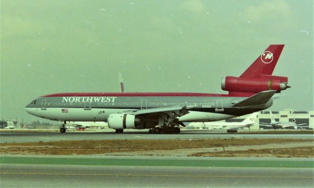 McDonnell Douglas DC-10 (N153US) - KLAX apprx March 1989 at the Imperial Terminal parking lot with a 6ft fence, this was an all day event and I may have even had to go get more film. The NWA DC10 shown here just landed on 25L and was following a UAL DC-10 to cross 25R and head to the Terminal. Looking back, I sure wish Digital cameras were available back then.....