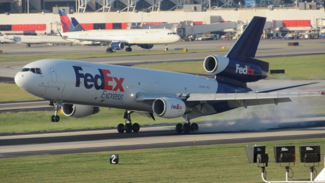 Boeing MD-11 — - This photo was taken of a FedEx MD-11 landing at KATL in October. just look at that amazing tire smoke. I took this at Renaissance hotel in Atlanta international, I highly recommend the hotel for any AVGeek staying in the Area!