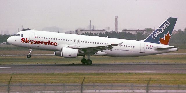 Airbus A320 (C-FTDQ) - A Skyservice A320 touches down on runway 05 at YYZ. Taken sometime in the late nineties, early 2000's, found a stash of old film and tried to recover some very degraded shots from my early spotting days!